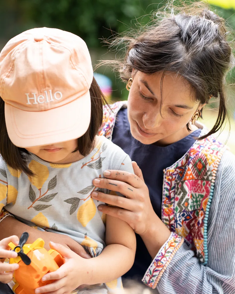 A teacher comforting a child in the garden