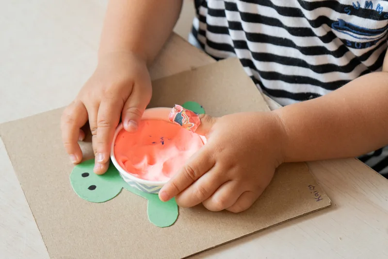 A Nursery child finishing a turtle craft